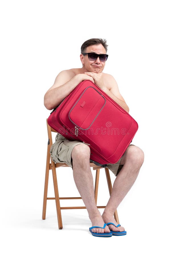Man in shorts and sunglasses sits on a chair with his hands hugging a red suitcase, waiting. Isolated on white background stock photo Man in shorts and sunglasses sits on a chair with his hands hugging a red suitcase, waiting. Isolated on white background stock photo
