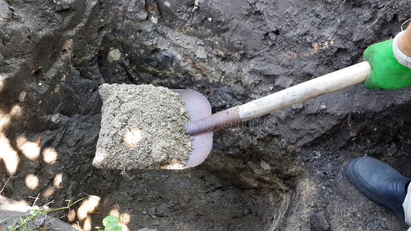 Man with shovel digging a hole in the ground stock image