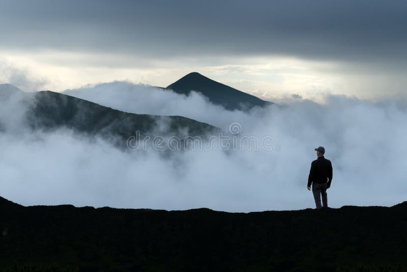 Man silhouette on cloudy mountains