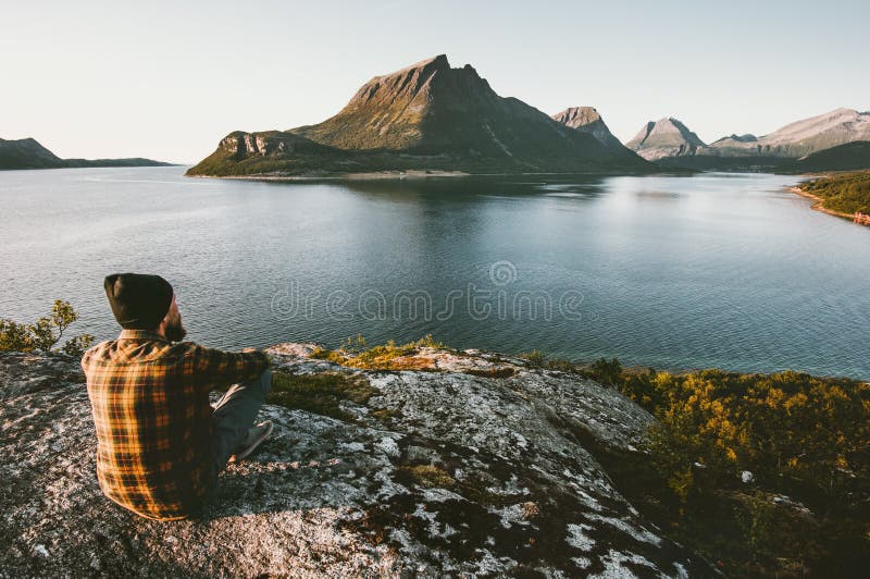 Man sitting alone enjoying sea and mountains view