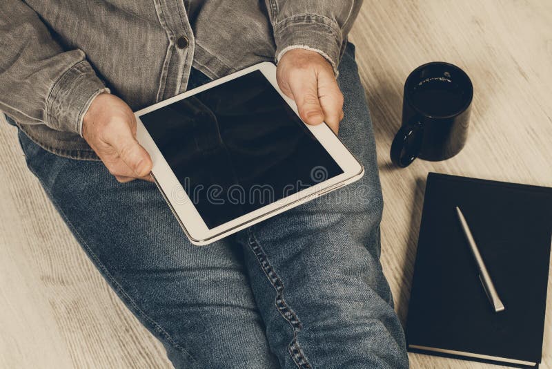 Man sitting on the floor working with a tablet royalty free stock image Man sitting on the floor working with a tablet royalty free stock image