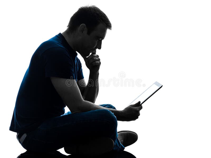 Man sitting holding watching digital tablet silhouette stock photo Man sitting holding watching digital tablet silhouette stock photo
