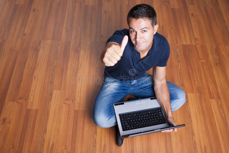 Man sitting with laptop and with his thumb up