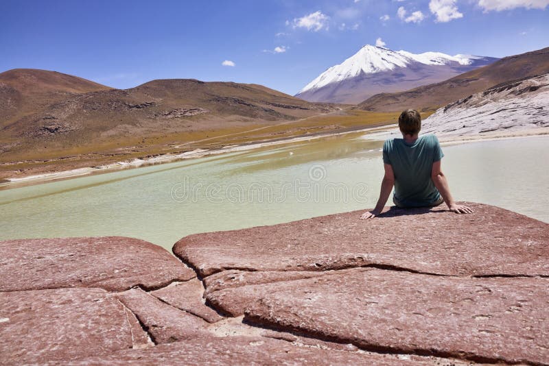 Man Sitting on the Piedras Rojas in Chile and Gazing at the Andes Mountains