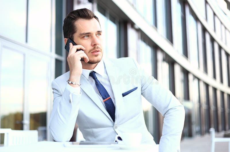 Man on smartphone - young business man talking on smart phone. Casual urban professional businessman using mobile cell phone smiling happy