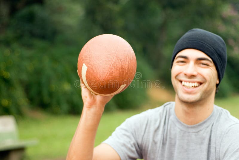 Man Smiling With Football - horizontal royalty free stock photo Man Smiling With Football - horizontal royalty free stock photo