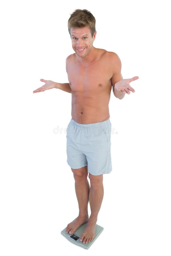 Man smiling while looking at his weigh on white background