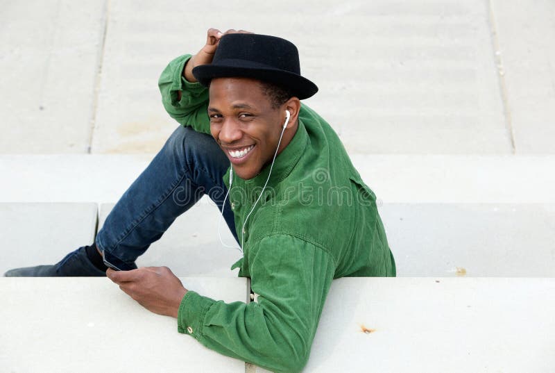 Man smiling outdoors with mobile phone