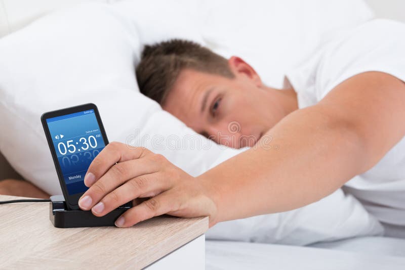 Man Snoozing Alarm Clock on Cell Phone Stock Image Image of house