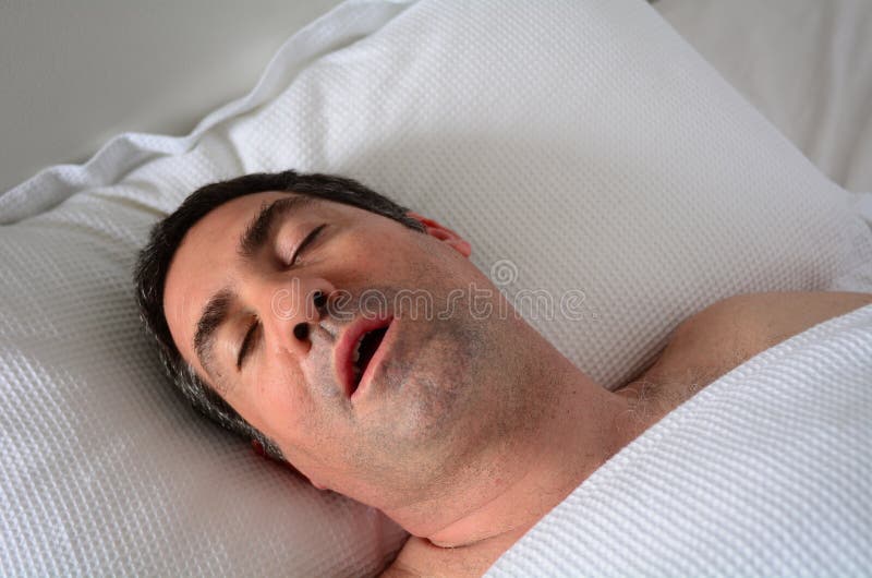 Hombre en su los cuarenta (4 0) ronquidos en una cama.