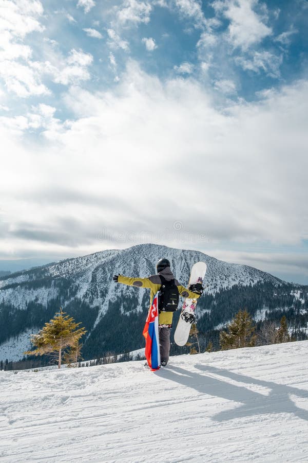 Man snowboarder with slovakia flag at ski resort slope