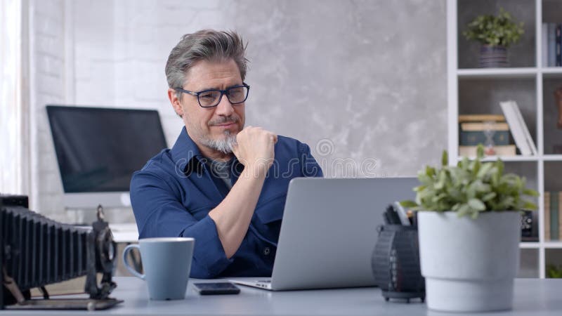 Man som arbetar med bärbar dator på hemkontoret arkivfoto