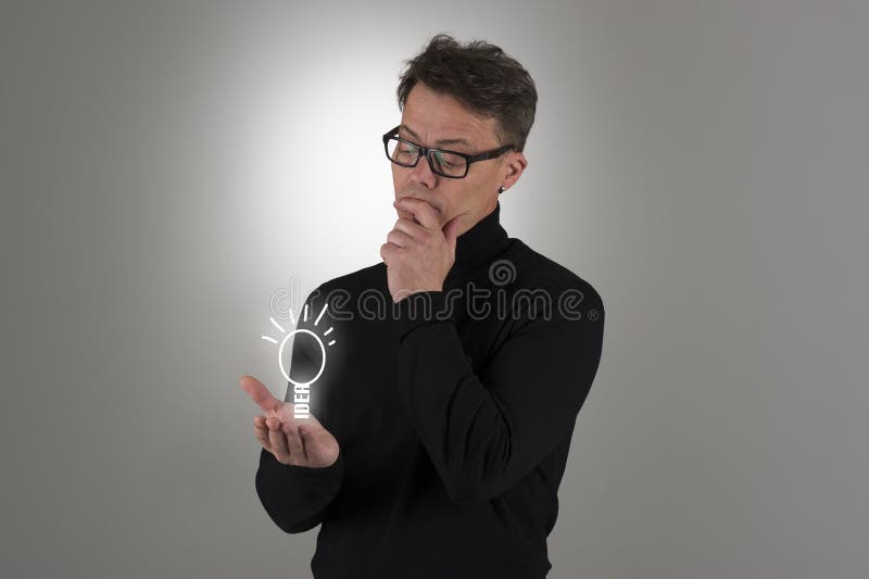 Man som beskådar en ljus idé royaltyfri foto Man som beskådar en ljus idé royaltyfri foto