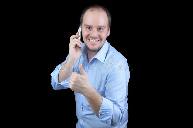 Man som ler den talande mobiltelefonen med tummar upp royaltyfri fotografi Man som ler den talande mobiltelefonen med tummar upp royaltyfri fotografi