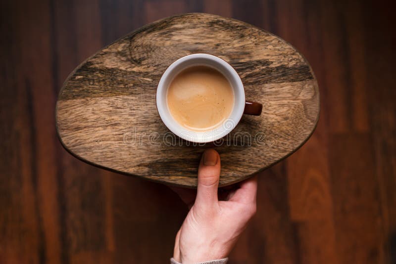 Man som rymmer en kopp kaffe på ett trä, tappningbakgrund Handen av den unga affärsmannen som rymmer, rånar av kaffe Tappningsign fotografering för bildbyråer Man som rymmer en kopp kaffe på ett trä, tappningbakgrund Handen av den unga affärsmannen som rymmer, rånar av kaffe Tappningsign fotografering för bildbyråer