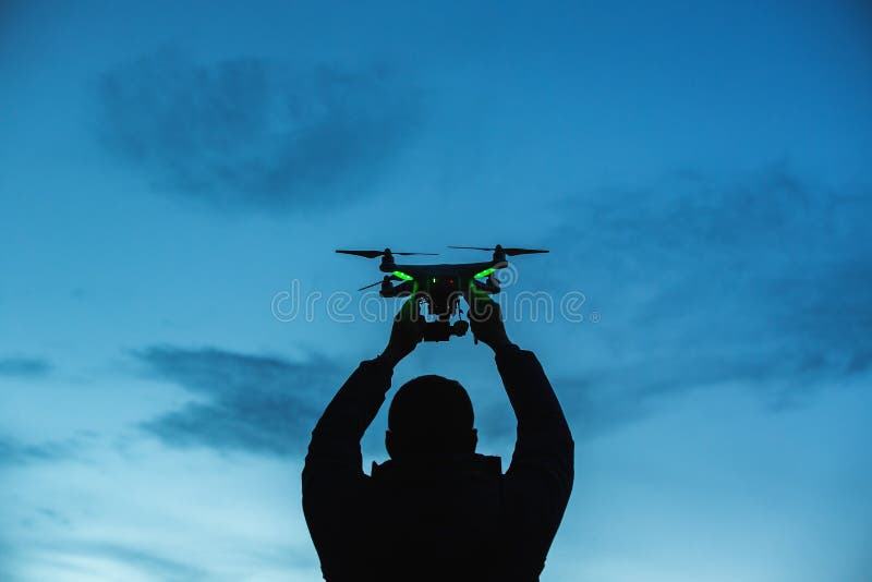 Man som rymmer ett surr för flygfotografering Kontur mot t royaltyfri fotografi Man som rymmer ett surr för flygfotografering Kontur mot t royaltyfri fotografi