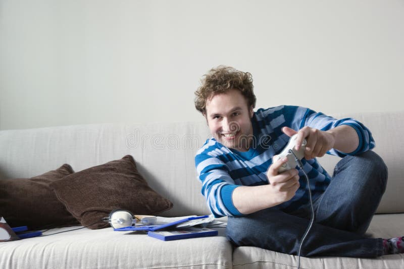 Man som spelar videospelet på soffan fotografering för bildbyråer Man som spelar videospelet på soffan fotografering för bildbyråer