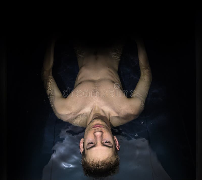 Man som svävar i en sensorisk förlustisoleringsbehållare royaltyfri fotografi Man som svävar i en sensorisk förlustisoleringsbehållare royaltyfri fotografi