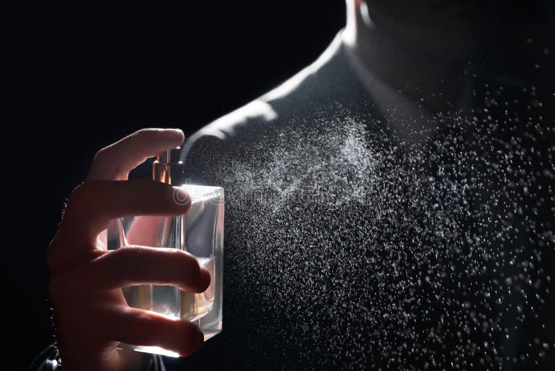 Man Spraying Luxury Perfume on Black Background, Closeup Stock Image