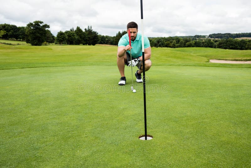 Man squatting to line up his putt