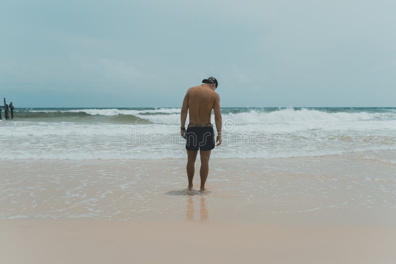 Man standing at the beach and watching the ocean royalty free stock images