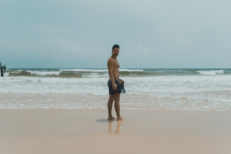 Man standing at the coast of Lazy Beach. Man standing at the beach and watching the ocean waves. Lazy beach, Koh Rong Samloem. Cambodia.