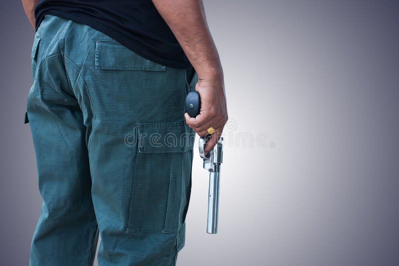 Man standing and hand holding gun revolver