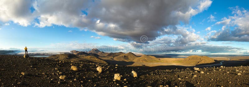 Man standing on mountain rock in dramatic illuminated landscape panorama in Iceland. Beautiful midnight sun scenery. royalty free stock photos Man standing on mountain rock in dramatic illuminated landscape panorama in Iceland. Beautiful midnight sun scenery. royalty free stock photos