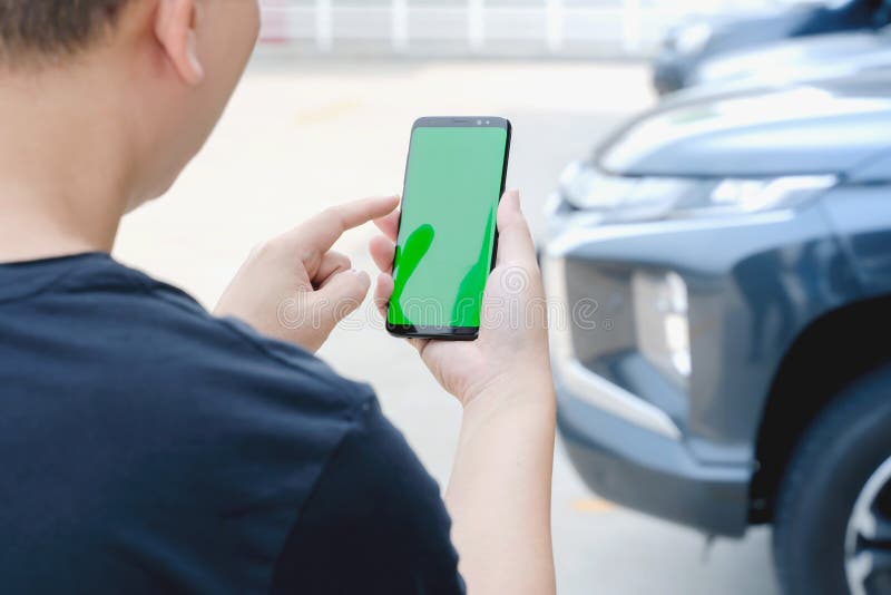 A Man standing next to the car. man using smartphone mockup green screen near the car. Mobile phone apps for car lock owners