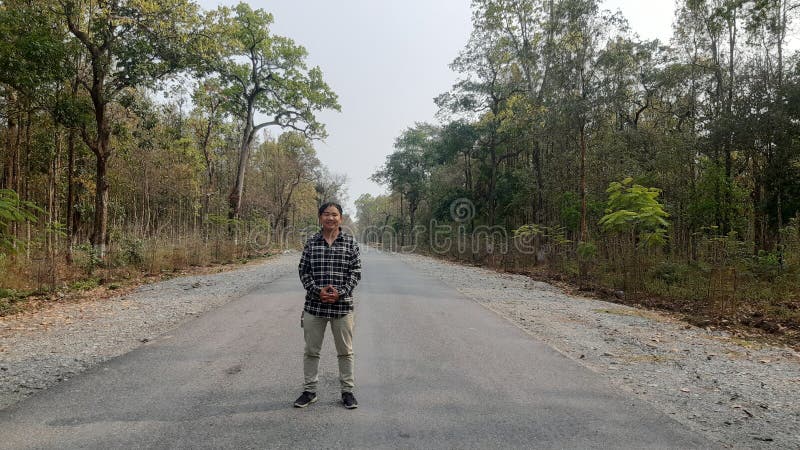 A Man Standing On The Pitch Road Surrounded By The Jungle Nepali Face a-man-standing-on-the-pitch-road-surrounded-by-the-jungle-nepali-face