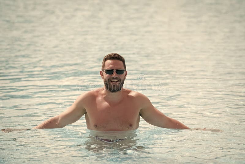 Man standing waist deep in blue sea water stock photo Man standing waist deep in blue sea water stock photo