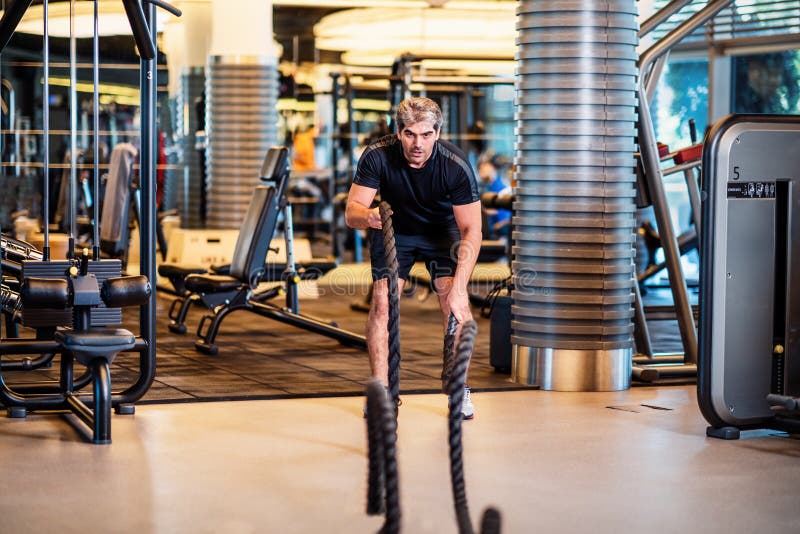 Man Strengthens Abdominal Muscles and Arm Muscles in the Gym with Rope ...