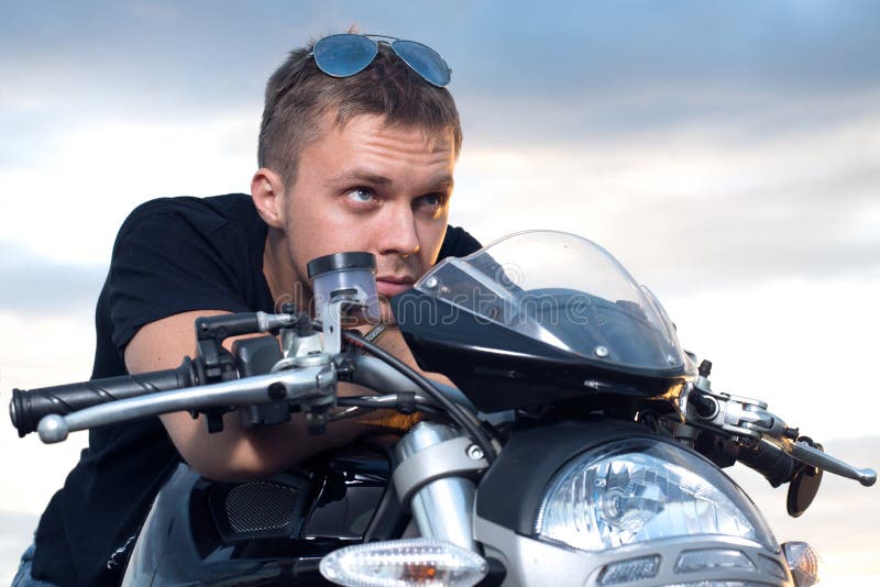 Man with a stubborn look leaned on the steering wheel of his bike