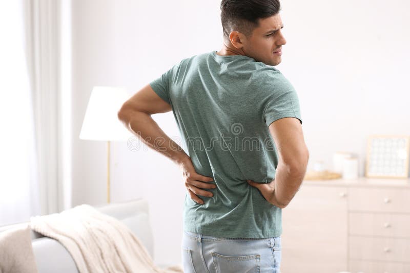 Man Suffering from Back Pain at Home. Bad Posture Problem Stock Image