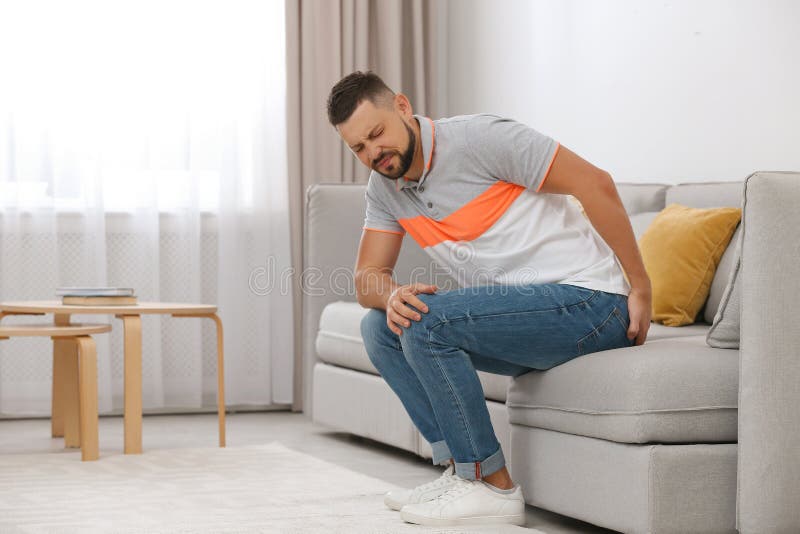Man suffering from hemorrhoid on sofa royalty free stock image Man suffering from hemorrhoid on sofa royalty free stock image