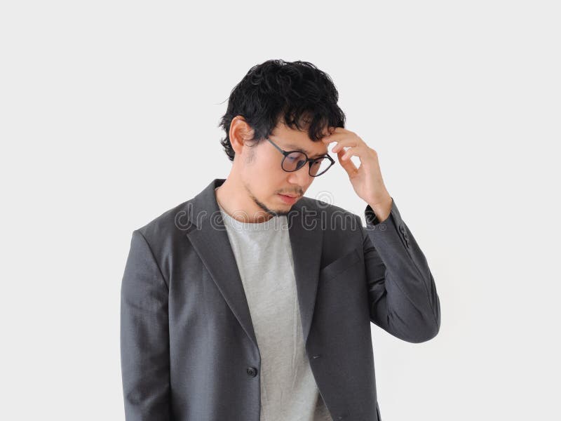 Man in a suit is looking down at his head stock photos