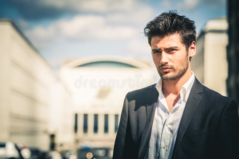 Man in suit and white shirt looking. Outdoors on the street in the city