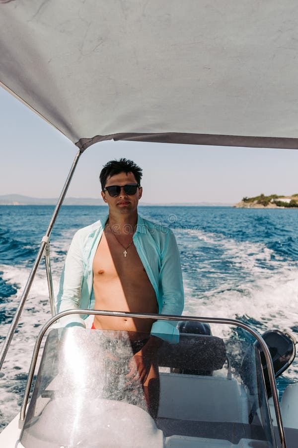 Man in Sunglasses Driving and Navigating Yacht in the Sea. Stock Image ...