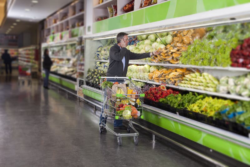 Man at supermarket and cellphone royalty free stock photography Man at supermarket and cellphone royalty free stock photography