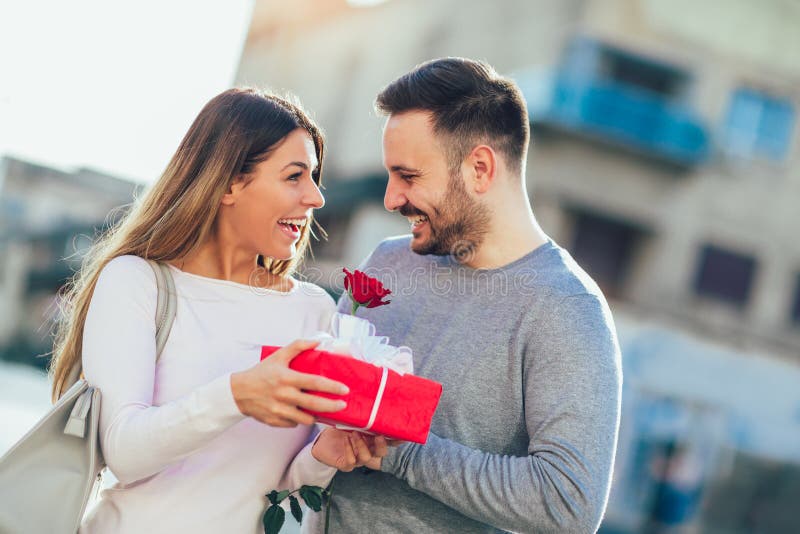 Man Surprises Woman with a Gift and Rose Stock Image - Image of ...