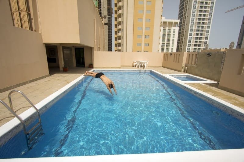 Man swim in swimming pool at roof of apartment, bahrain