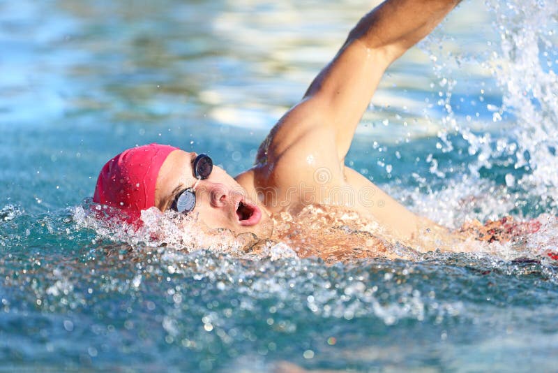 Man swimmer swimming crawl in blue water stock photography