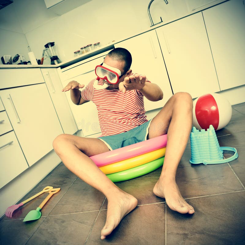 Man swimming in an inflatable water pool, indoors, with a dramat