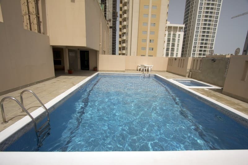 Man in swimming pool at roof of apartment in Bahrain