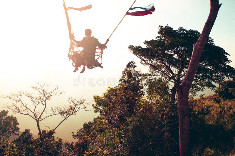 Man Swinging on Swing at the End of the World. Stock Photo Image of