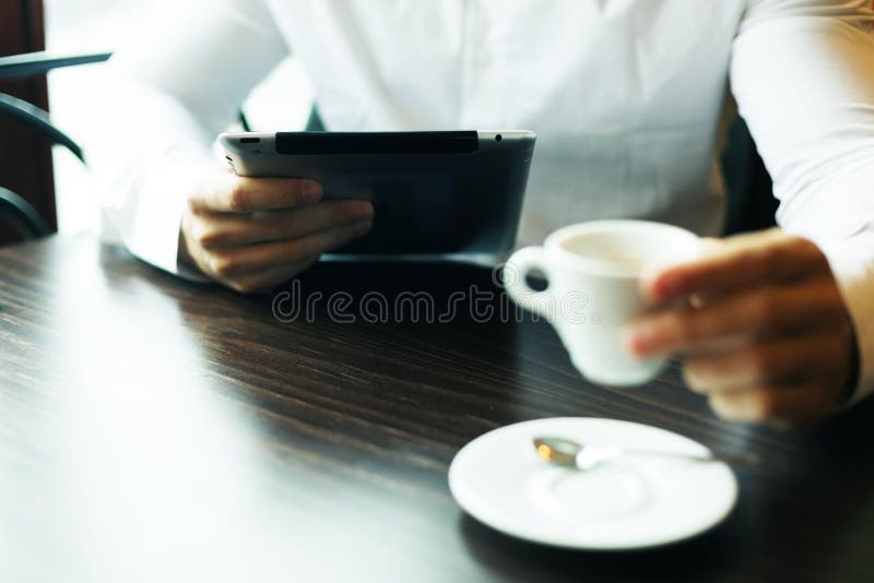 Man with tablet computer and coffee reading news at motning