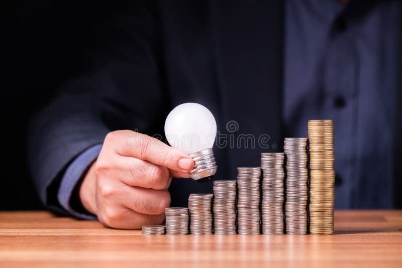 Small light bulb step up on the heap coins royalty free stock photo