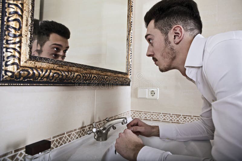 Man takes a look at himself in the mirror.