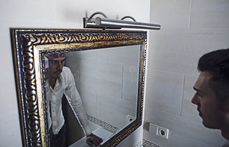 Man takes a look at himself in the mirror.