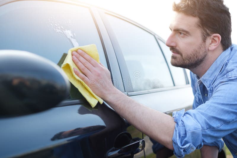 Fixes his car. Man Cleaning his car.